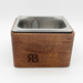 Wooden espresso knock box with metal inset on a white background