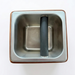 Wooden espresso knock box with metal inset on a white background